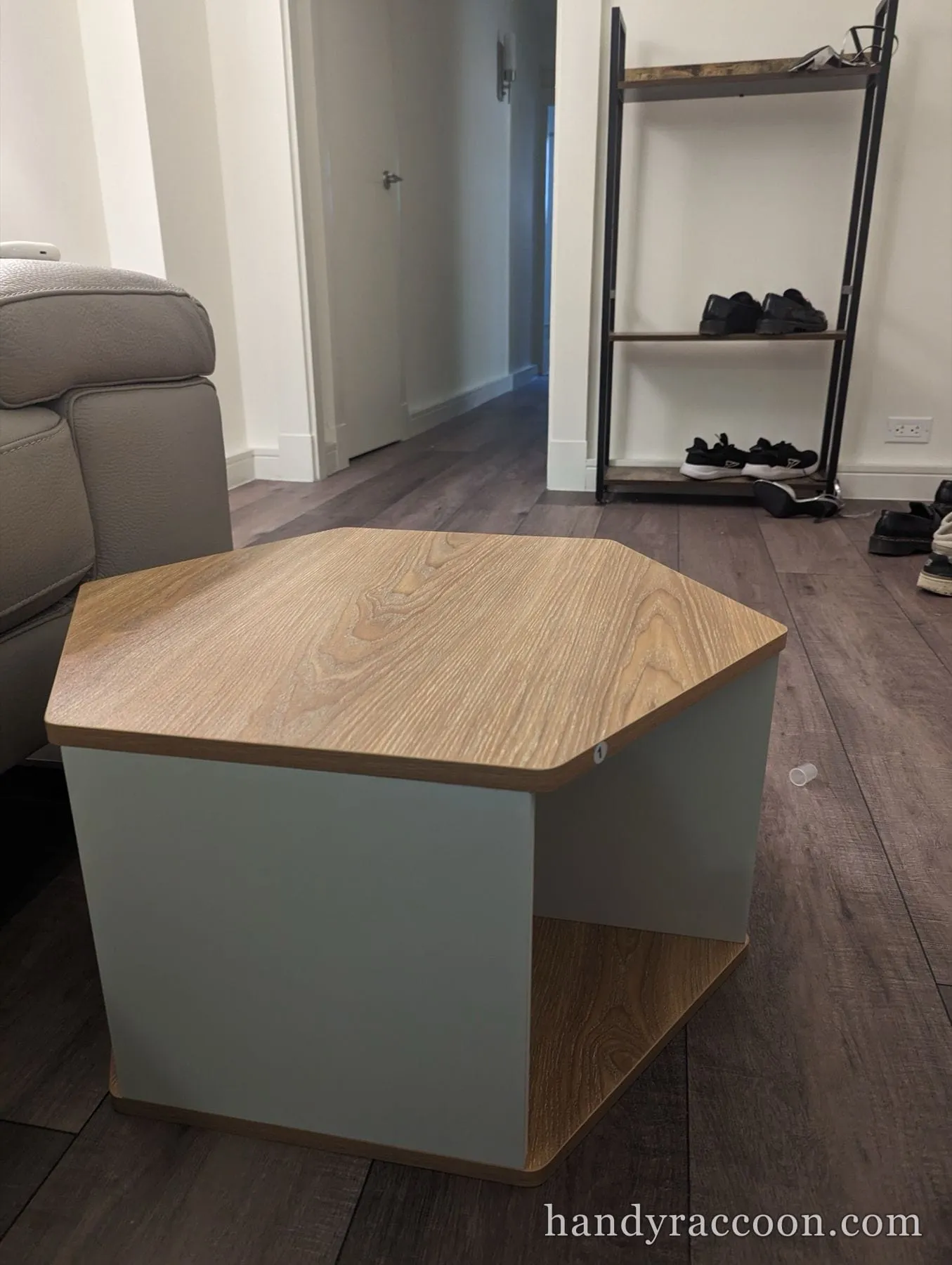 Sage green hexagonal coffee table with a wood-grain top on a living room floor.