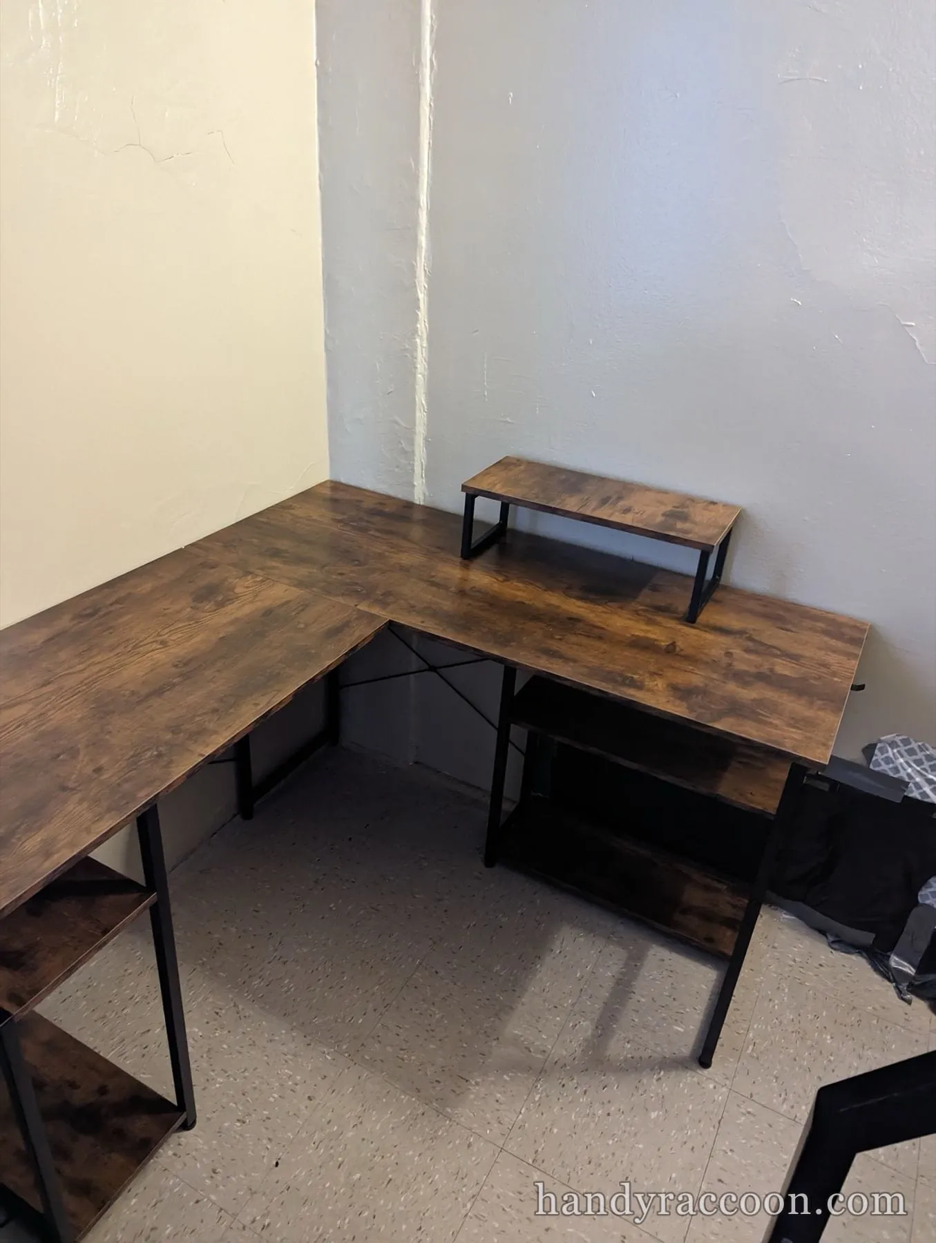 Rustic brown L-shaped desk with black metal legs, side shelves and a small riser shelf.