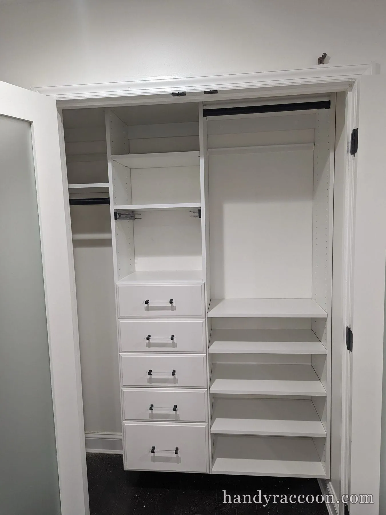 White closet organizer with drawers, adjustable shelves, and hanging rods installed.
