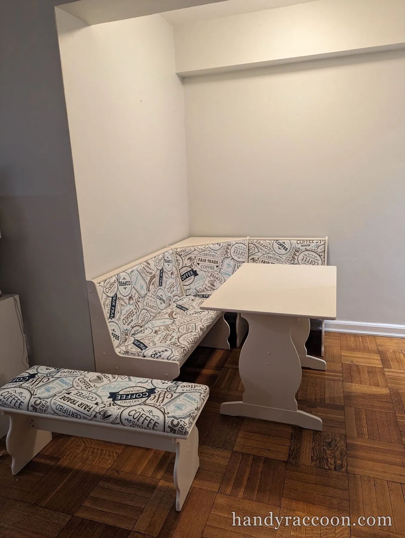 White L shaped corner bench set and trestle table with coffee themed upholstery.